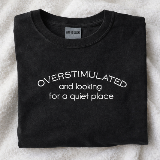 Black t-shirt with white embroidered text on a white background