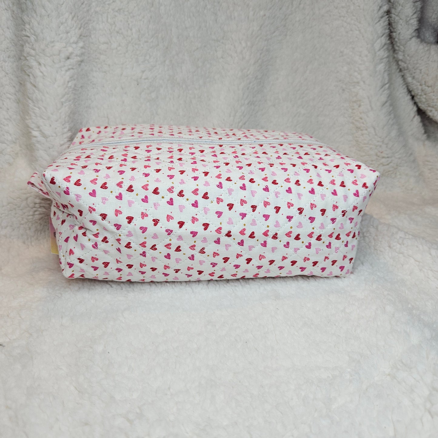 Boxy bag with pink heart pattern on a gray surface