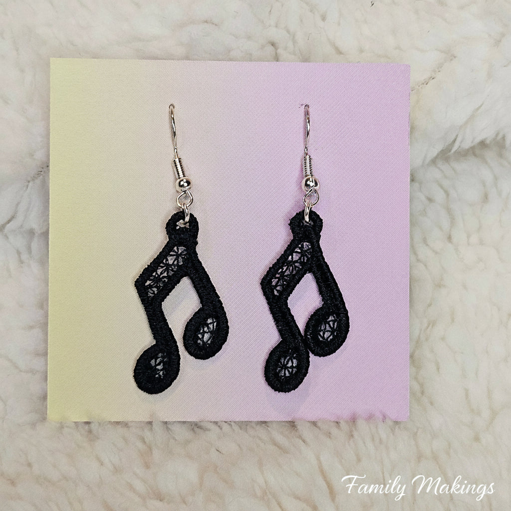 Beamed Eighth Note embroidered earrings with black thread and silver posts on a card