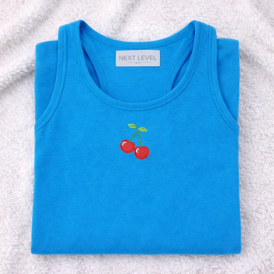 Turquoise tank top with cherry design on a textured surface