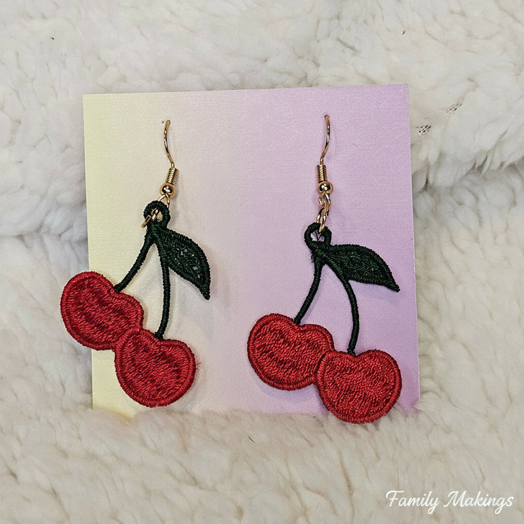Embroidered cherry earrings with gold posts on a card