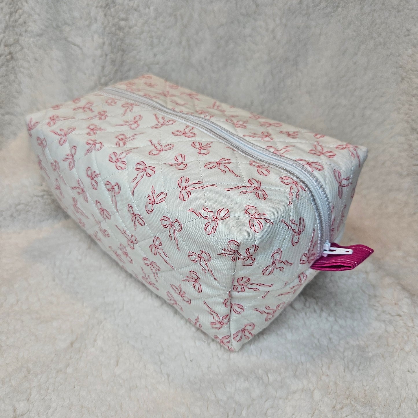 Small pouch with bow pattern on a soft gray background